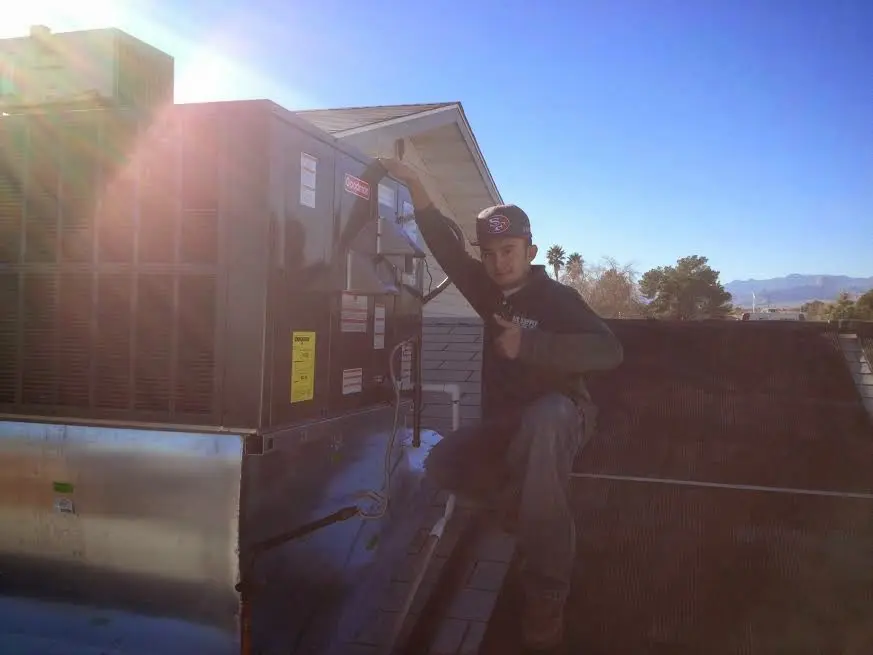 HVAC technician performing Boiler Repair on a rooftop unit in Meredith